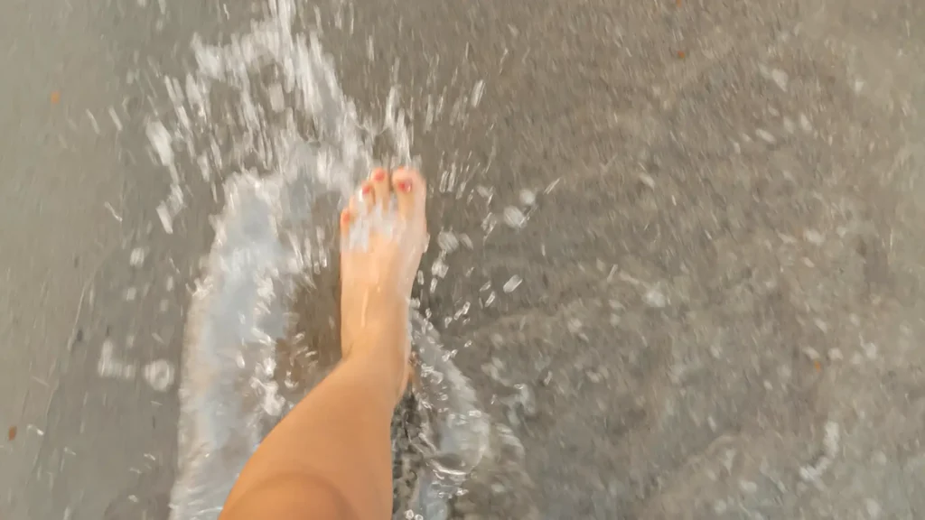 Pie de mujer en la orilla del mar.